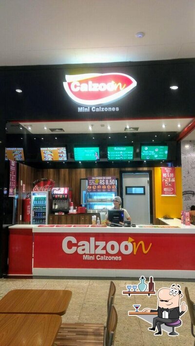 Sente em uma das mesas no Calzoon Sucos e Calzones