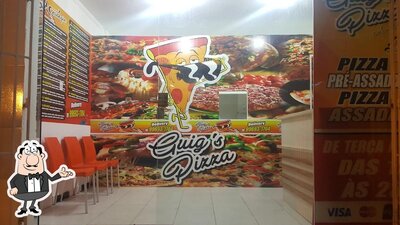 Sente em uma das mesas no Guig's Pizza